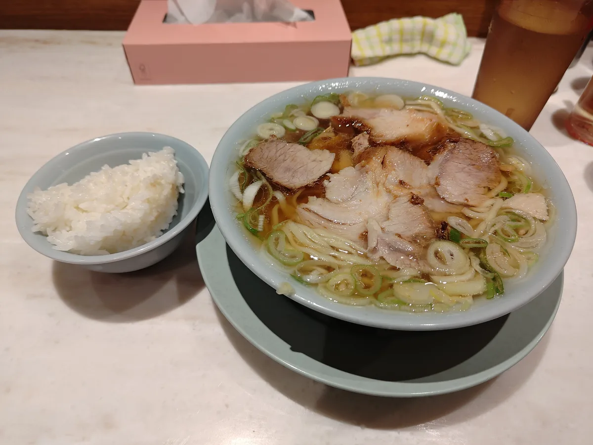 Chashu-men Ramen und kostenloser Reis bei Chiechan Ramen in Kanda, Tokio. Klarer Shoyu (Soja Sauce) buta-chintan (Schweinebrühe) mit dicker Fettschicht, viel Chashu und weichen Nudeln.