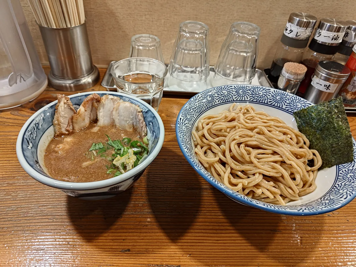 Noko Nikuiri Tsukemen at Dogenzaka Manmosu in Shibuya, Japan. This Japanese ramen dish features rich tonkotsu gyokai dipping soup, tender chashu pork, and signature thick wheat germ noodles, served with nori.