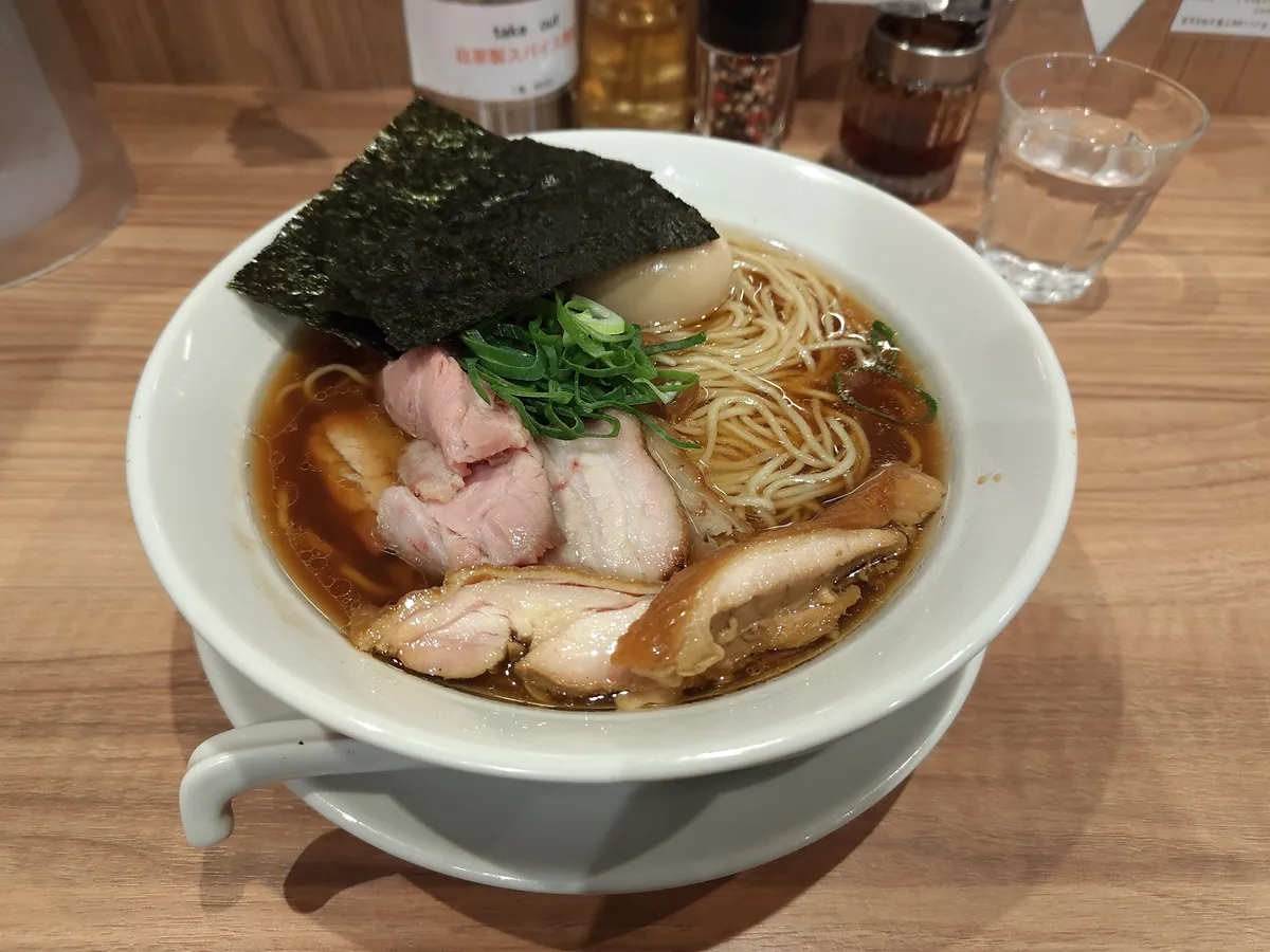 特製醤油ラーメン。透き通った醤油スープに極細麺、鶏と豚の2種チャーシュー、半熟味玉、海苔、ネギが美しく盛り付けられている。
