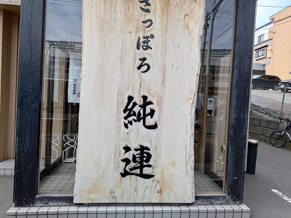 さっぽろ純連 札幌本店の入口。木製の大きな看板が目印。