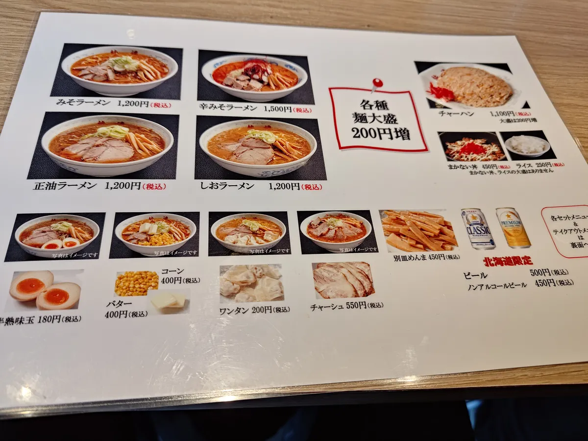 卓上メニュー。みそラーメン、辛みそラーメン、正油ラーメン、しおラーメンなどの写真と価格が一覧で確認できる。トッピングも掲載。